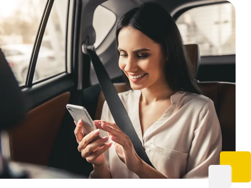 Frau sitzt im Taxi und schaut auf Smartphone